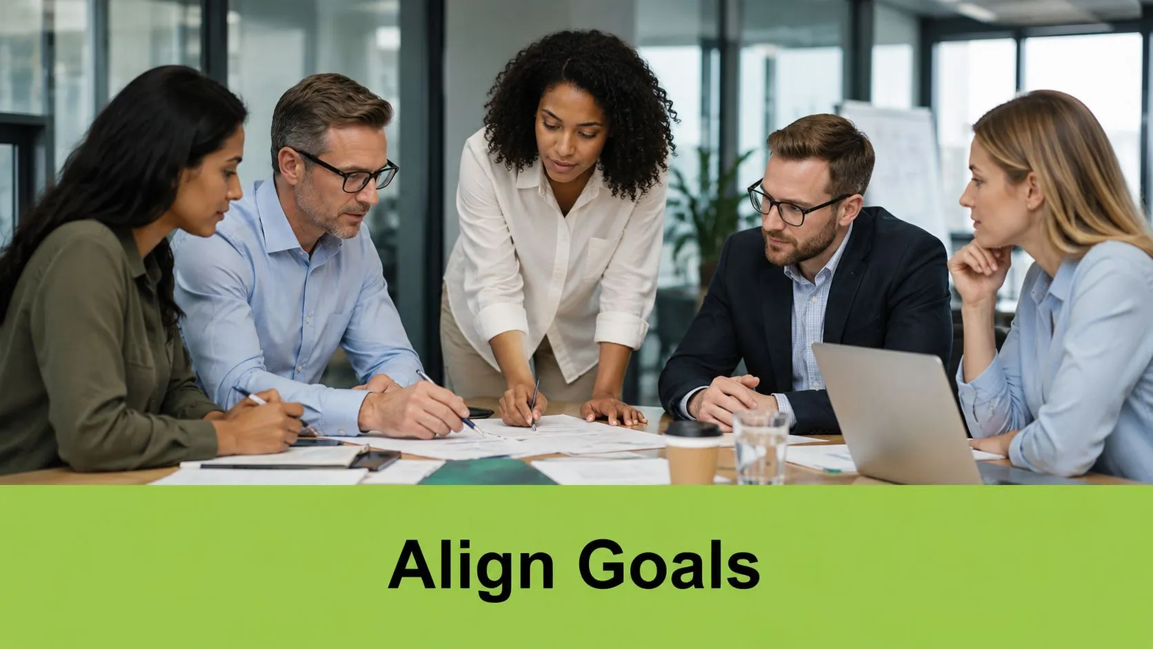 A diverse team of professionals collaboratively discussing strategic plans and documents around a conference table in an office.